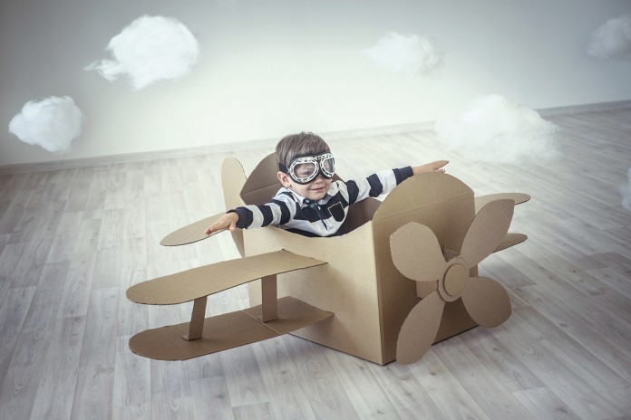 Niño jugando en un avión de cartón