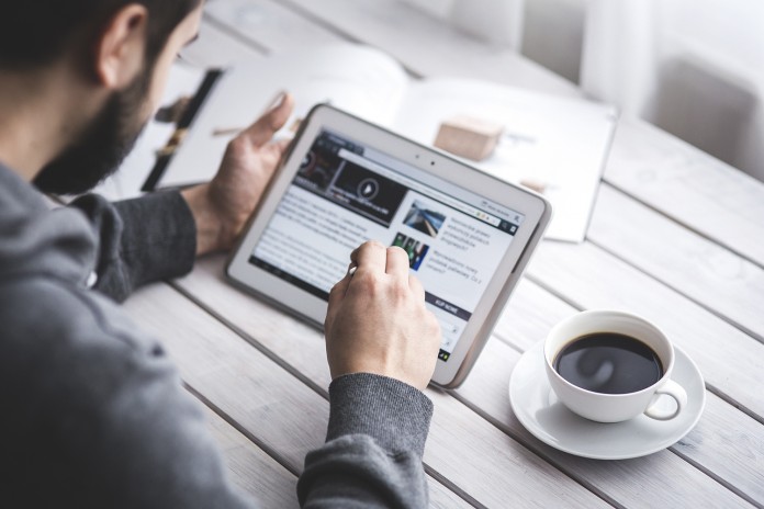 Man with coffee and tablet