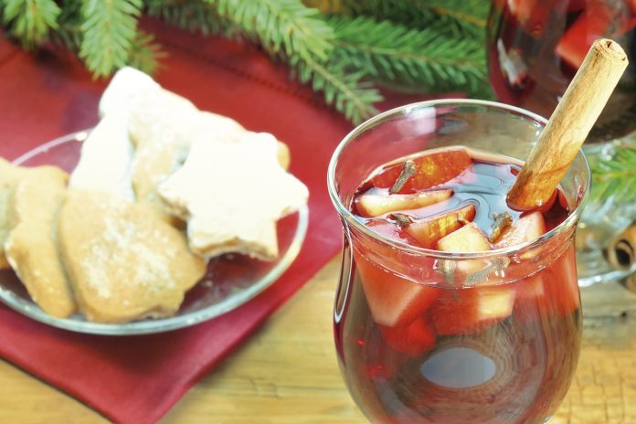 Mulled wine with cinnamon sticks and christmas cookies