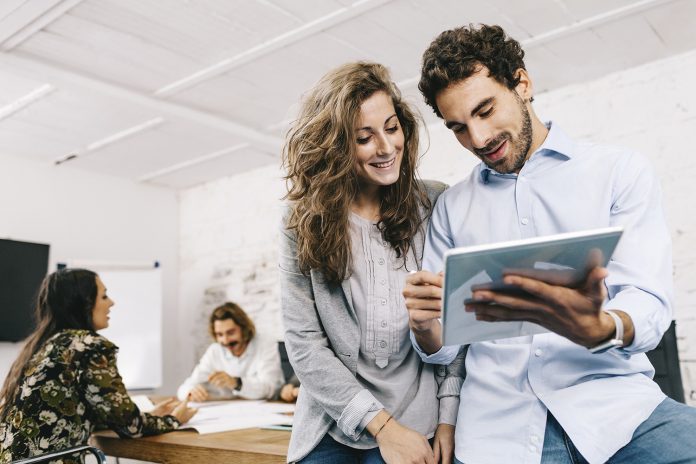 Young businesswoman and businessman working in office