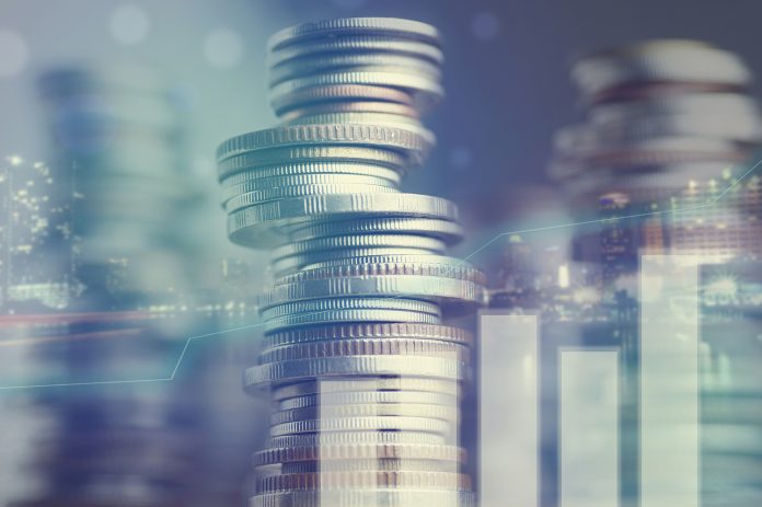 Double exposure of city and graph on rows of coins