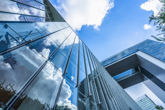 blue sky and clouds reflected at glass wall