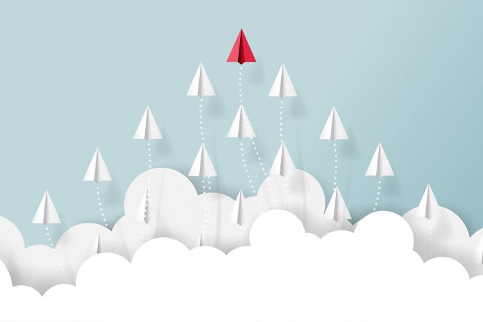 Paper airplanes teamwork flying from clouds