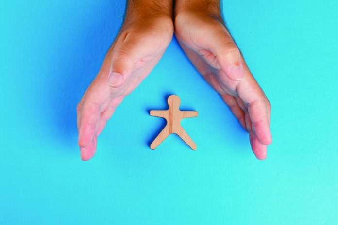 Social protection concept on blue background flat lay. hands tak Ética y sostenibilidad, pilares del negocio